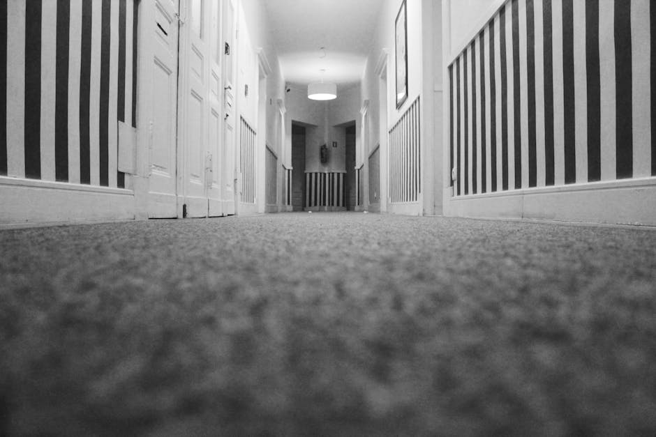 Three professional cleaners from Wimbledon Carpet Cleaners are performing surface cleaning and deep cleaning of a residential living room. They are equipped with vacuum cleaners and mop tools, and are